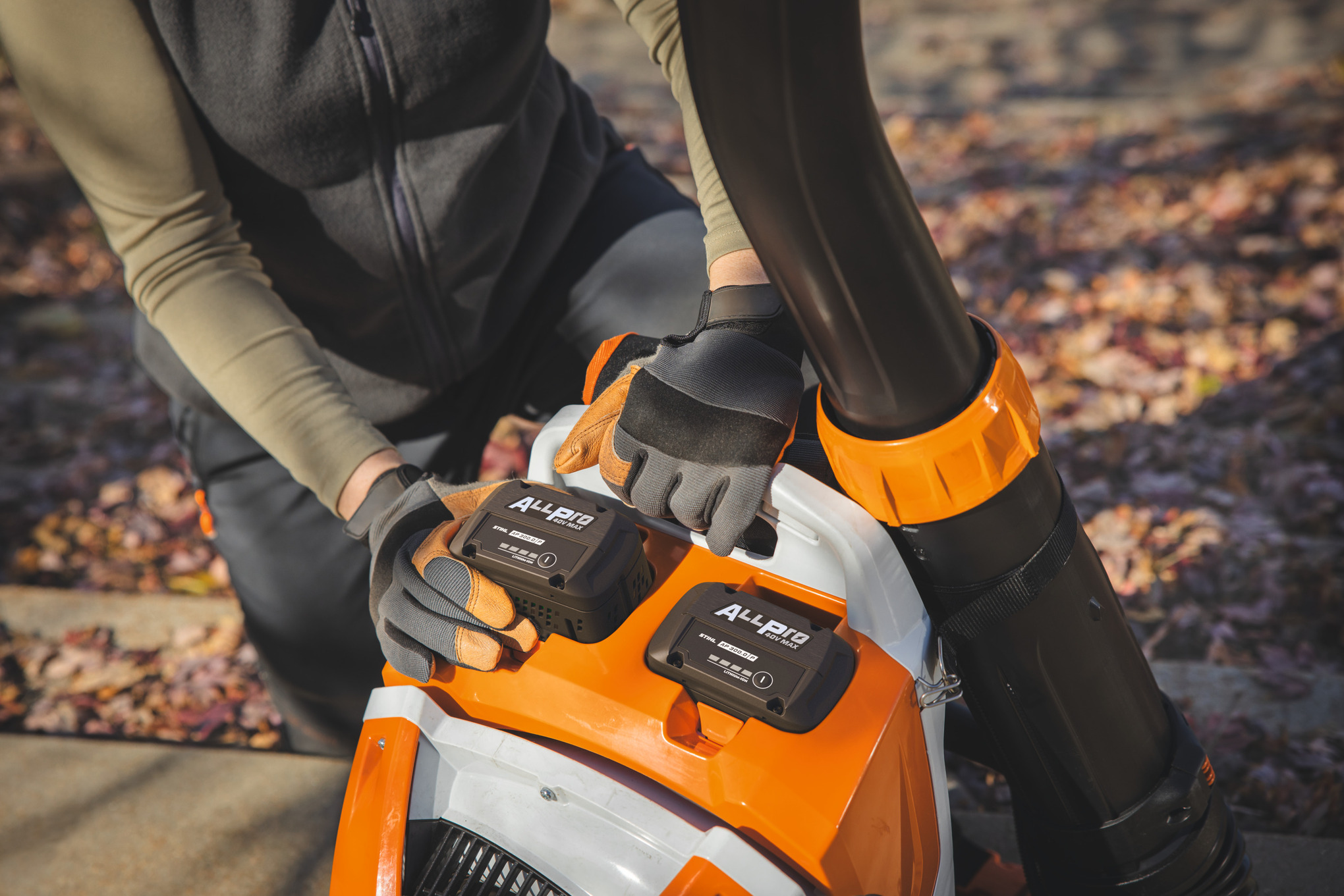 Um paisagista profissional coloca a segunda bateria STIHL AP 300.0 P no soprador de mochila a bateria da STIHL