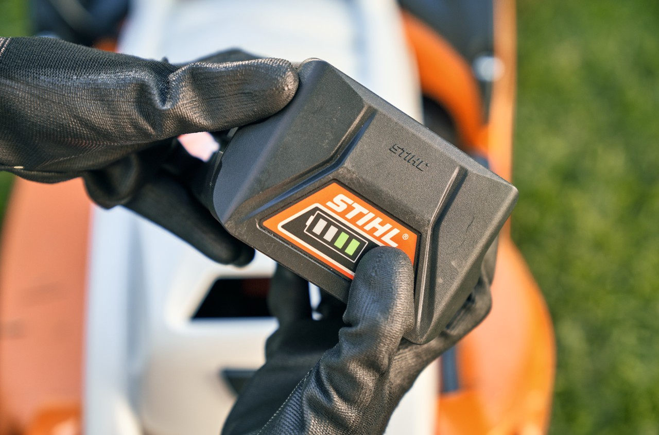 Bateria de íons de lítio STIHL, em segundo plano um cortador de grama a bateria STIHL RMA 339 C