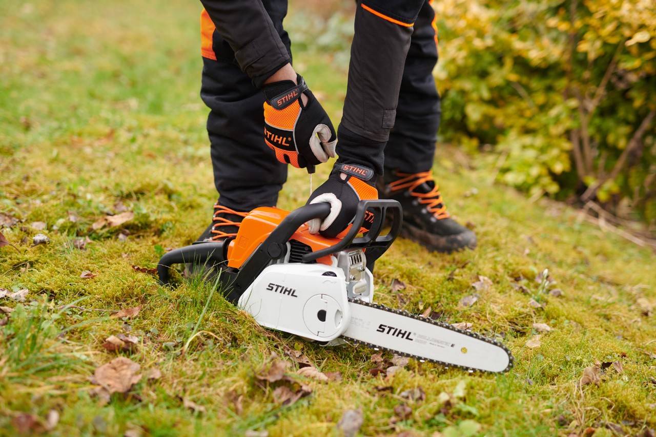 Ligar a motosserra a gasolina STIHL MS&nbsp;180&nbsp;C-BE no chão
