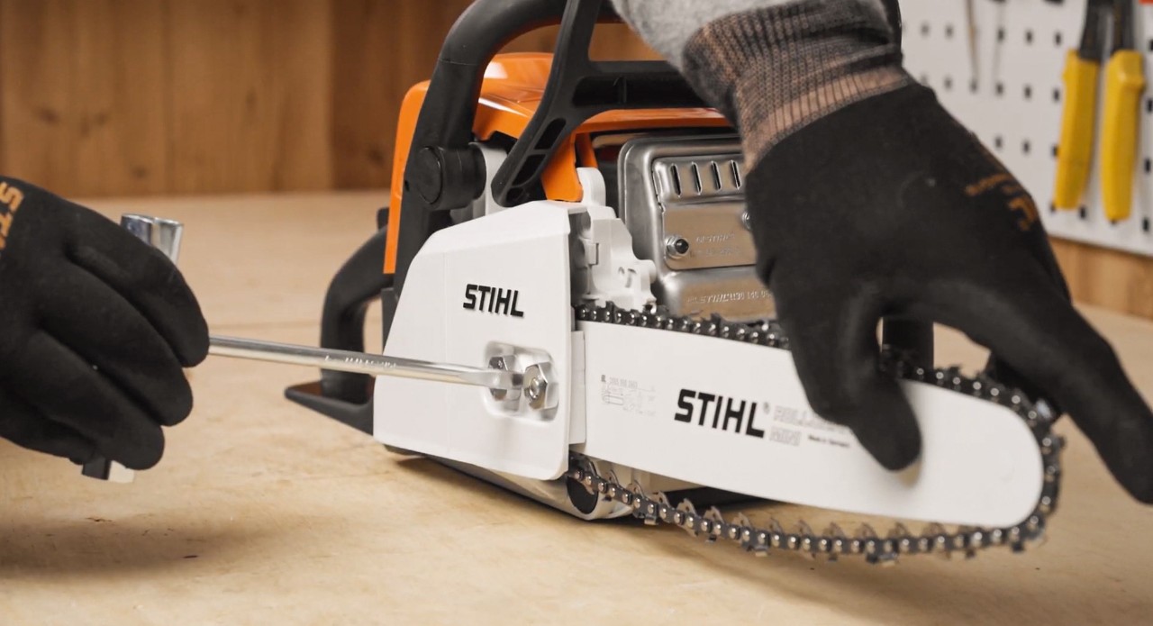 Uma motosserra STIHL numa bancada com STIHL sendo realizada manutenção da corrente