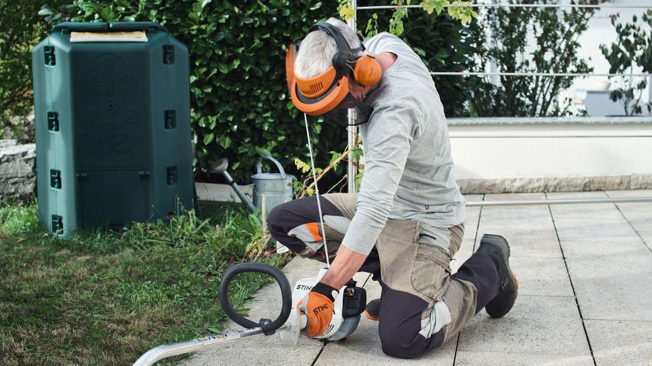 Alguém com vestuário de proteção volta a puxar a corda de arranque da motorroçadora a gasolina STIHL FS&nbsp;38