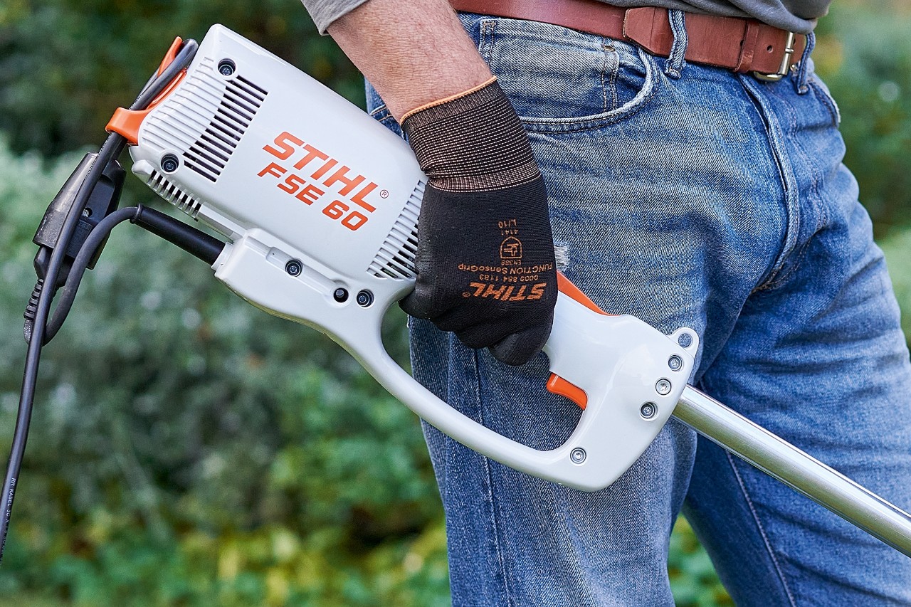 Um homem aciona o interruptor para desligar a motorroçadora elétrica STIHL FSE&nbsp;60.