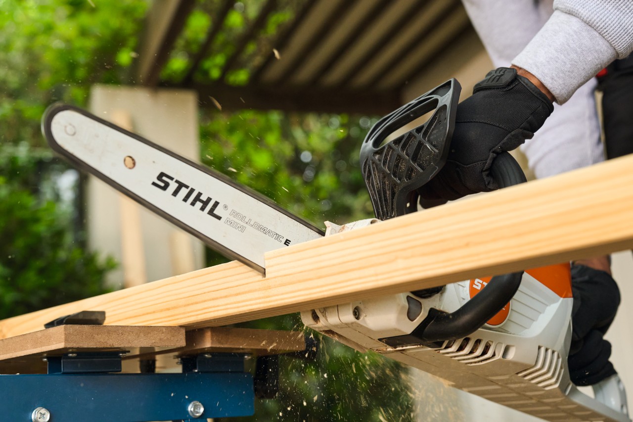Um homem serra uma barra lateral para uma goleira de futebol com uma STIHL MSA 70