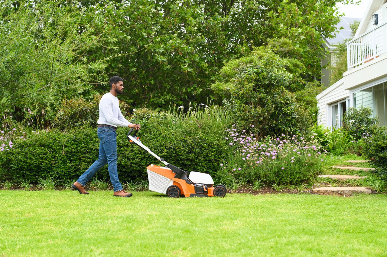 Um homem corta a grama com um cortador de grama STIHL RMA 448 V