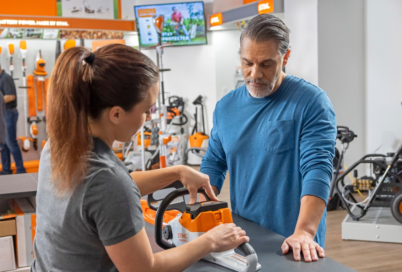 Funcionária da loja  STIHL ajuda um cliente 