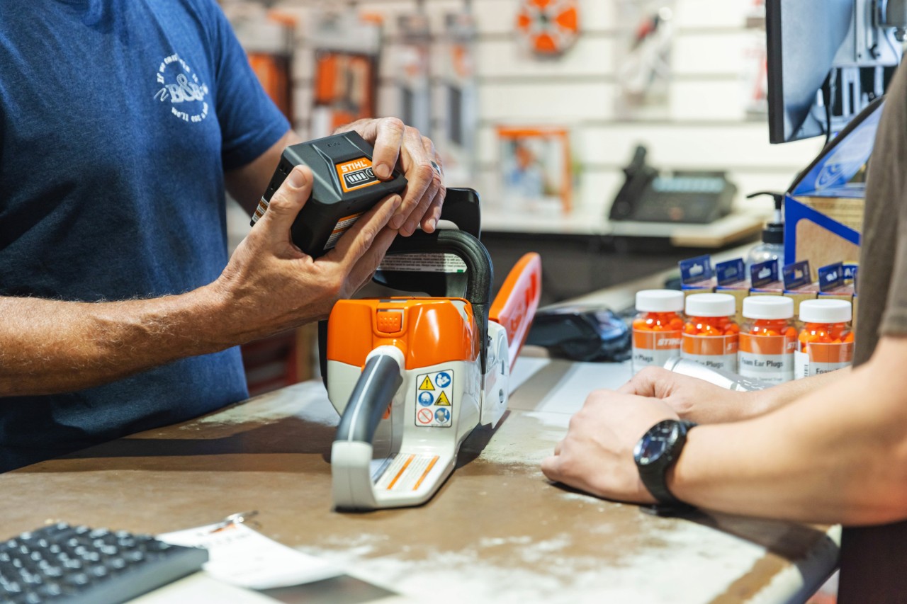 Funcionário da loja  STIHL ajuda um cliente 
