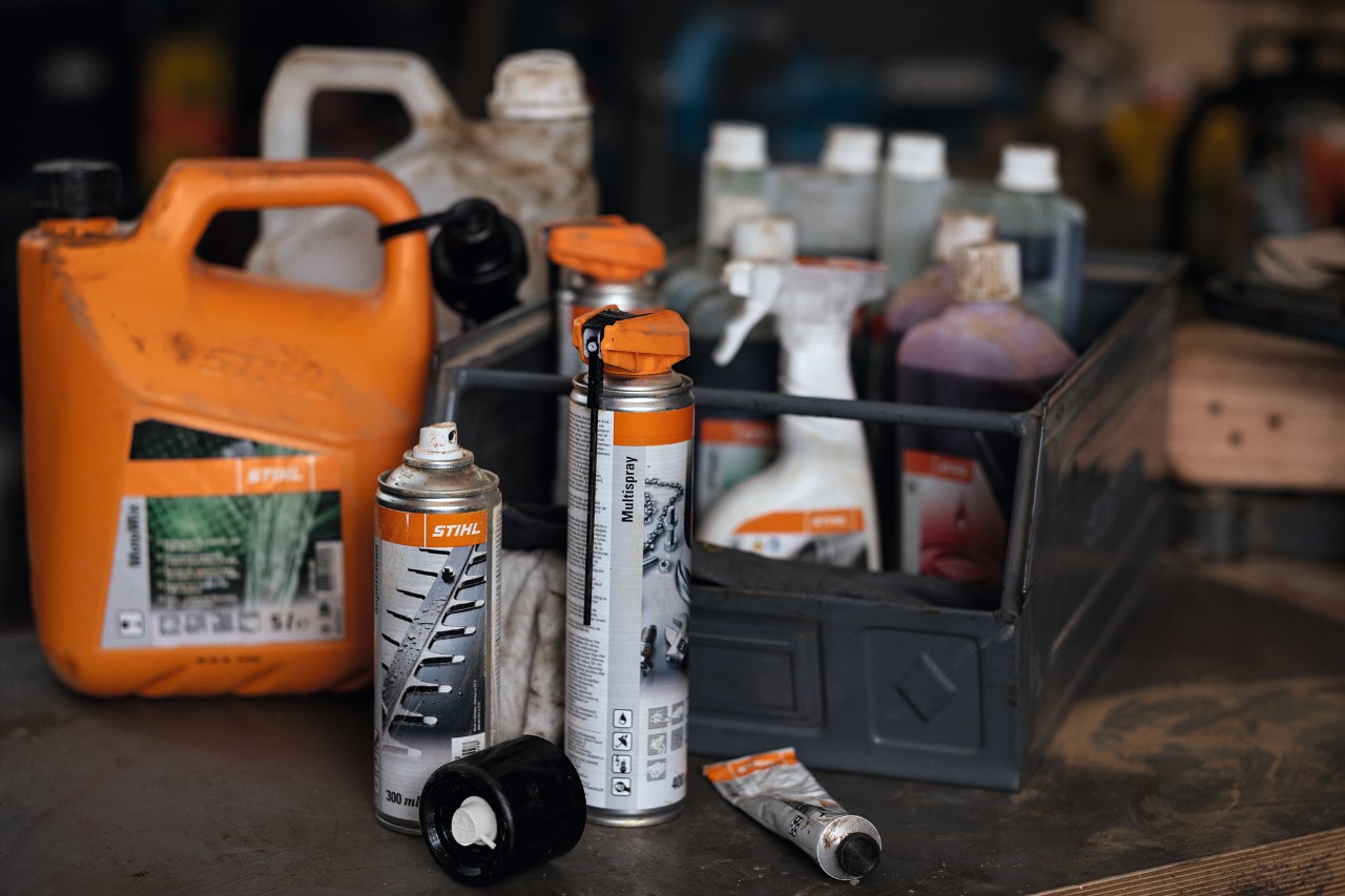 Diferentes combustíveis e lubrificantes da STIHL, alguns deles numa caixa