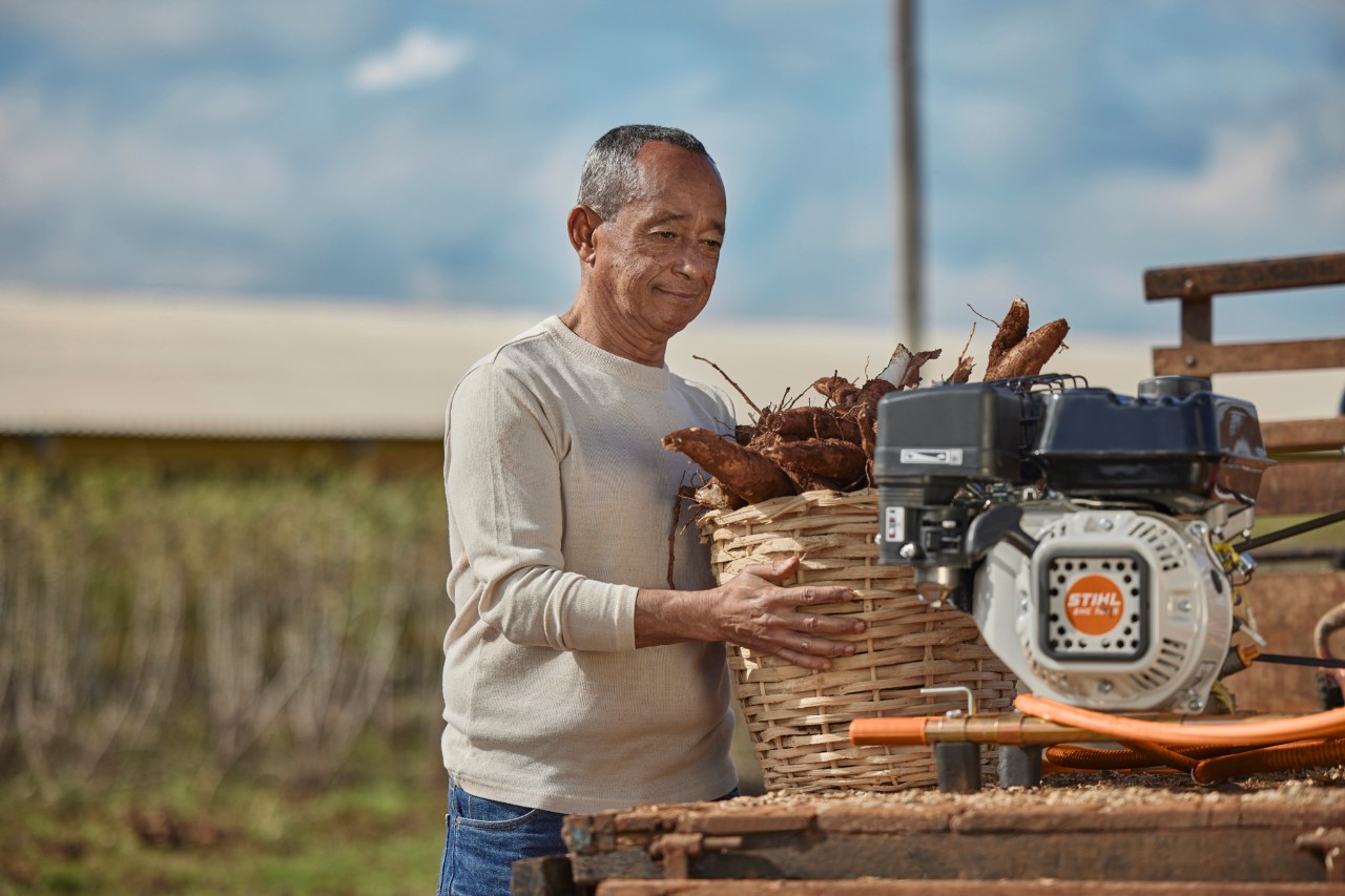 Um senhor com o motor estacionário em cima de uma carroça 