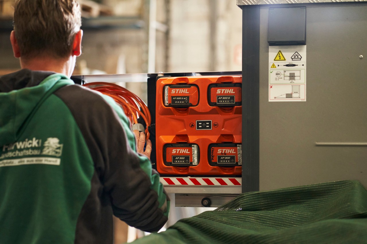 Um colaborador da Farwick GmbH de costas em frente a um bottTainer powered by STIHL