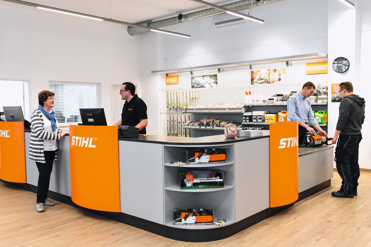 Área de vendas de um concessionário especializado STIHL com funcionários e clientes  