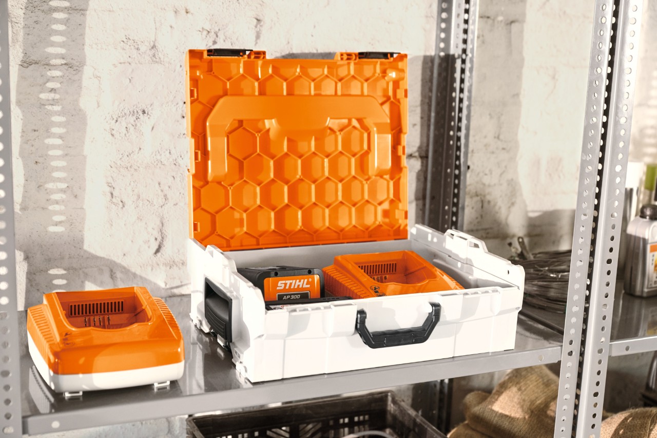 Caixa para bateria STIHL com baterias STIHL numa estante de oficina  